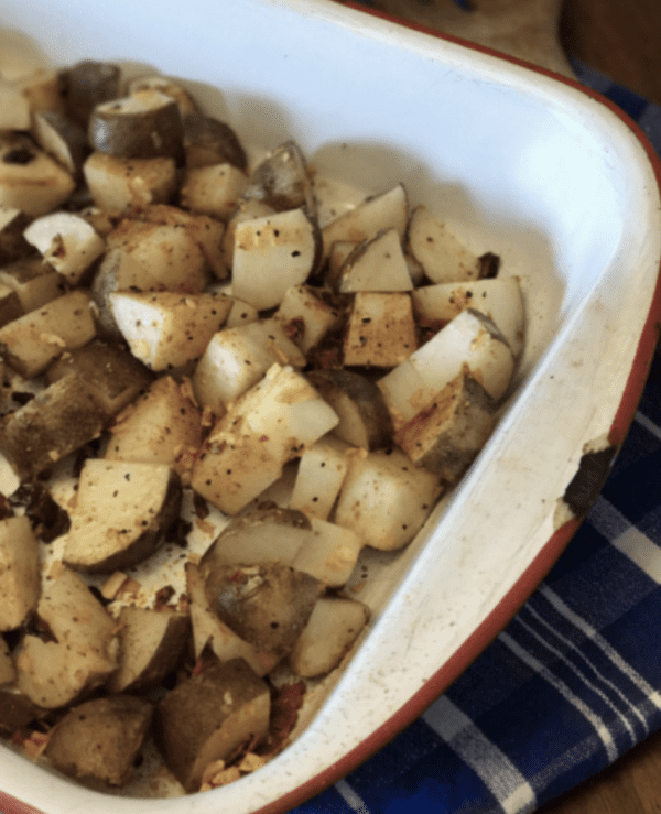 Seasoned potato wedges in a baking dish.